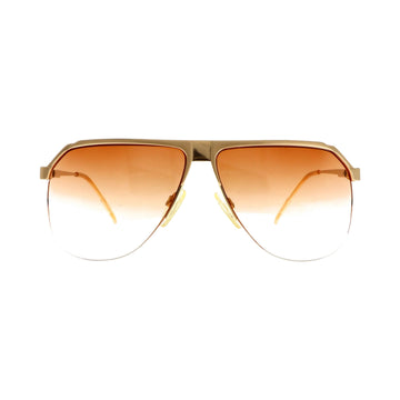 Gucci GG 1202 sunglasses with gold front, stylish eyewear featuring a sleek design and dark tinted lenses.